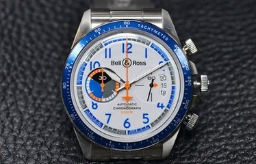 The orange hands and blue Arabic numerals hour makers are in contrast to the white dial.